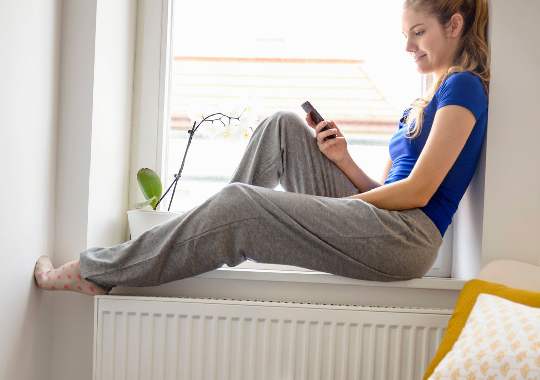 jeune femme assise sur le rebord d'une fenetre